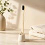Bamboo toothbrush in a ceramic holder on a bathroom counter