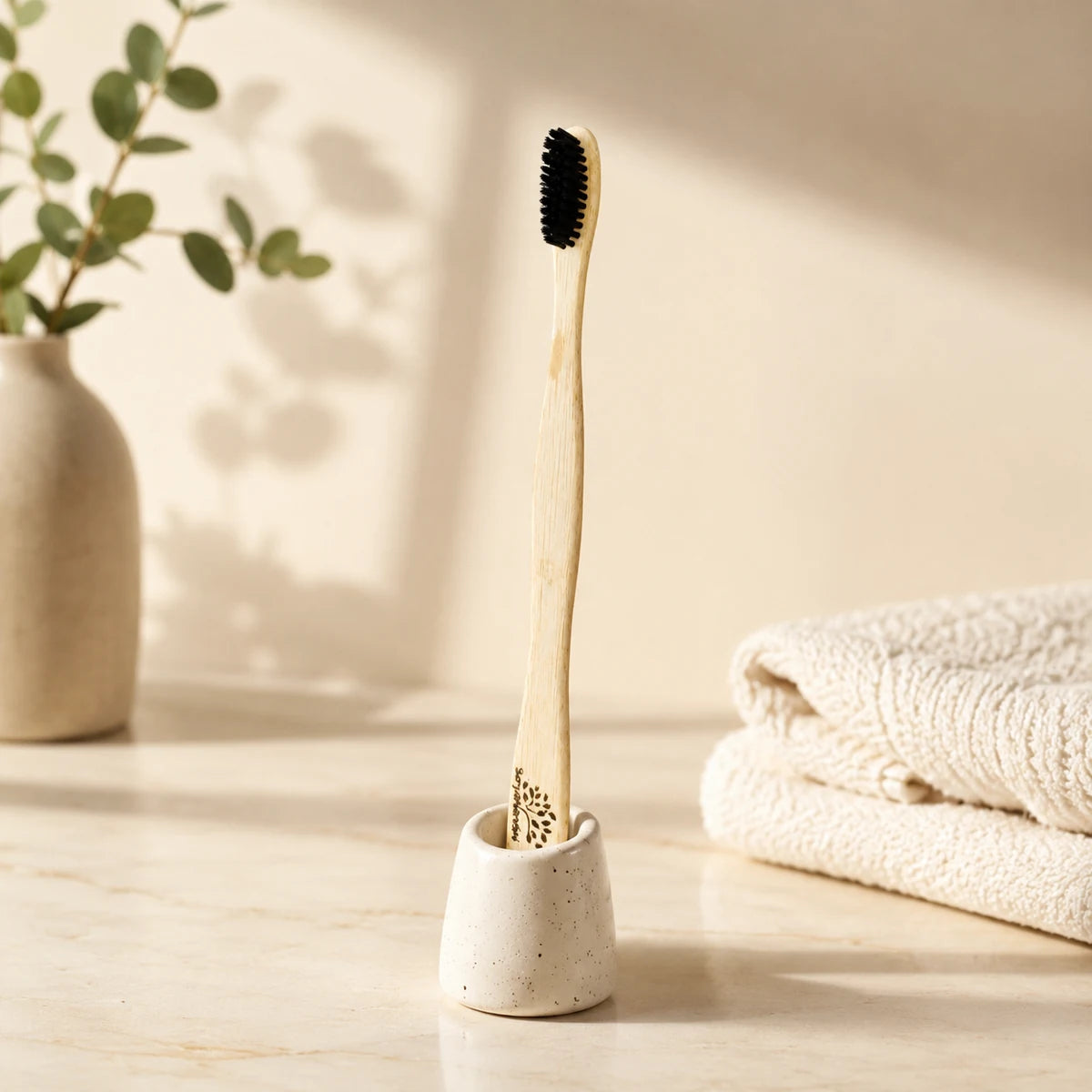 Bamboo toothbrush in a ceramic holder on a bathroom counter